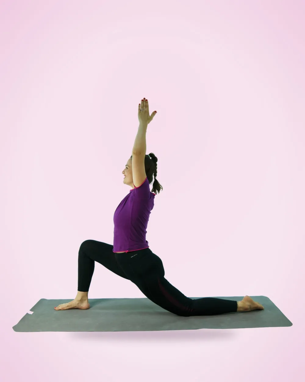 Tea într-o fandare de yoga, cu brațul ridicat, zâmbind