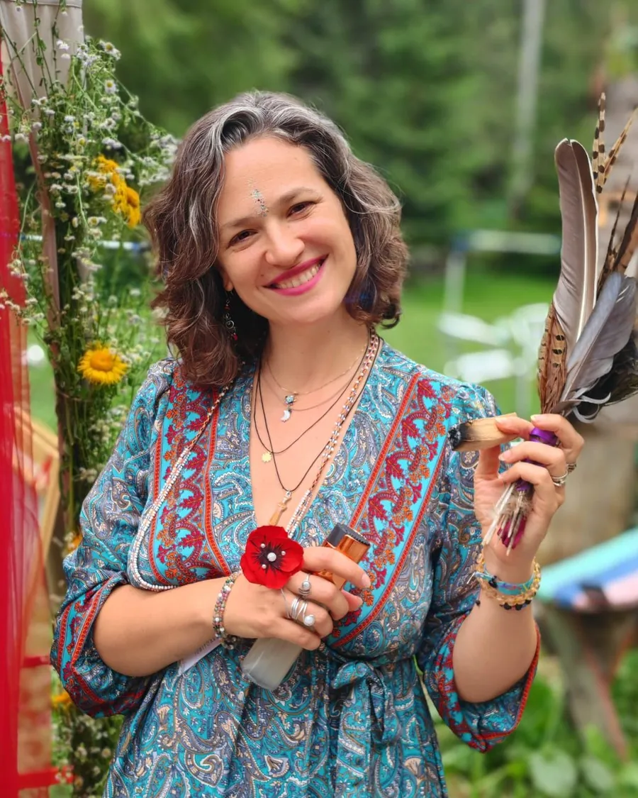 Teodora Haidu zâmbind în grădină, cu pene în mână