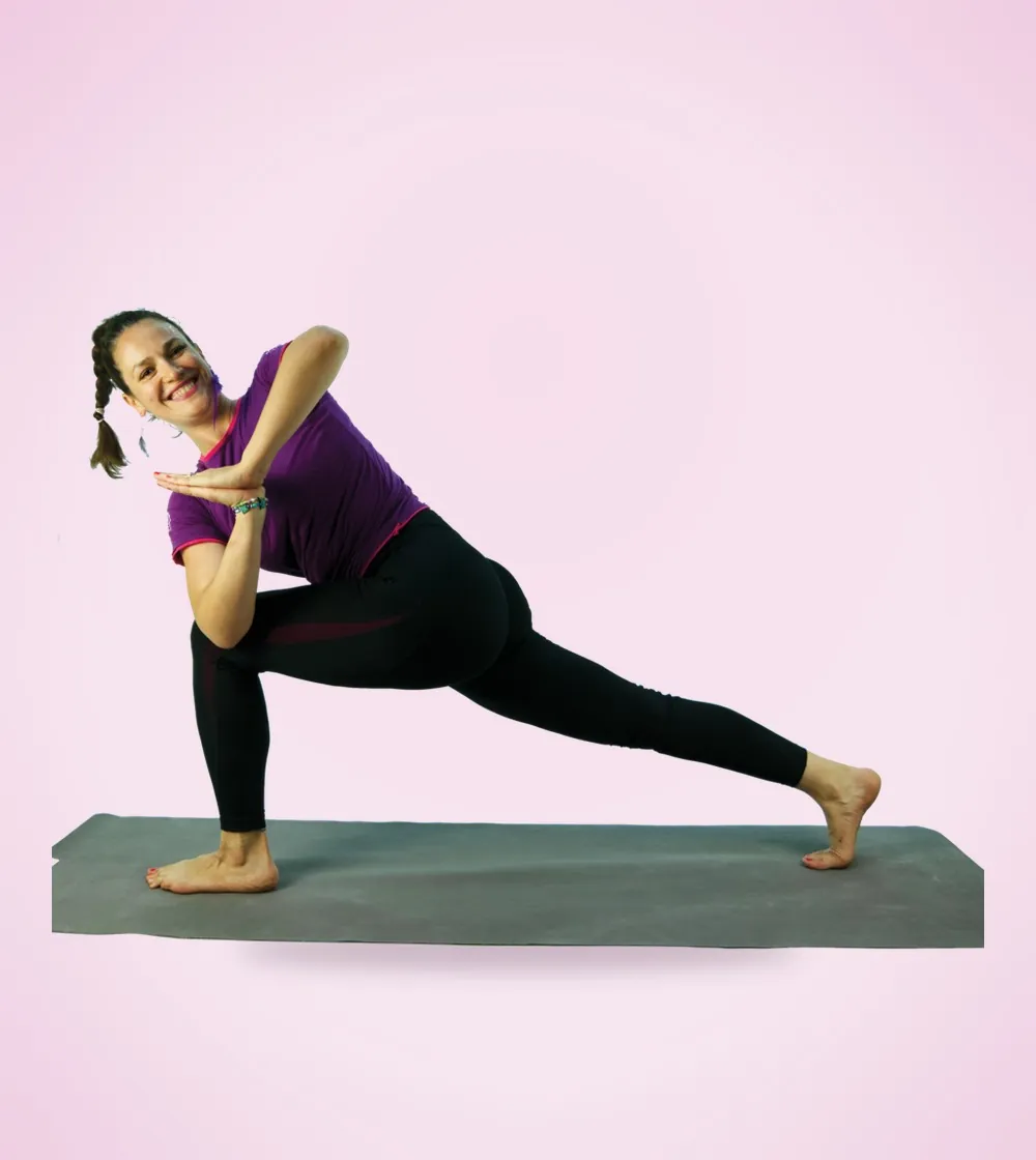 Tea într-o postură de yoga răsucită, zâmbind larg